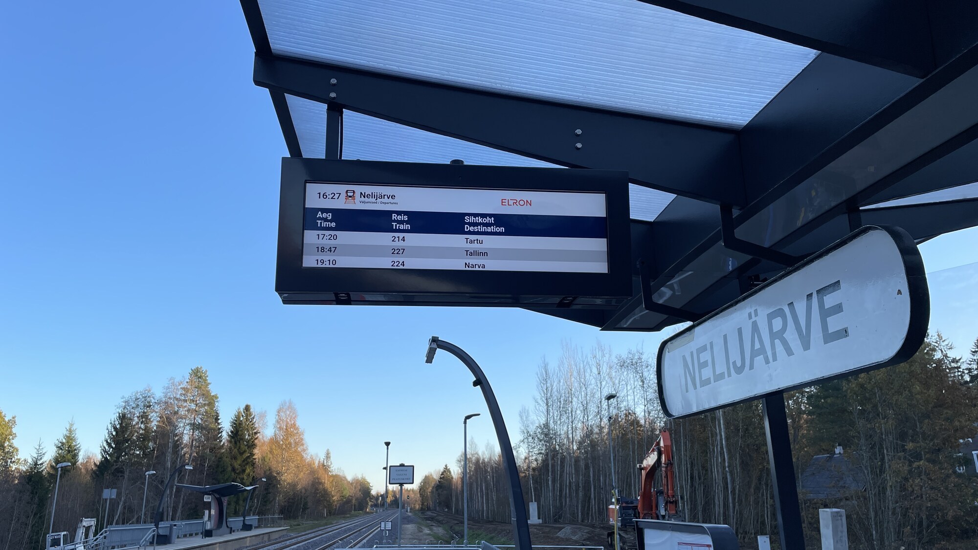 Narrow outdoor LCD passenger information display under the platform canopy at Nelijärve station, Estonia