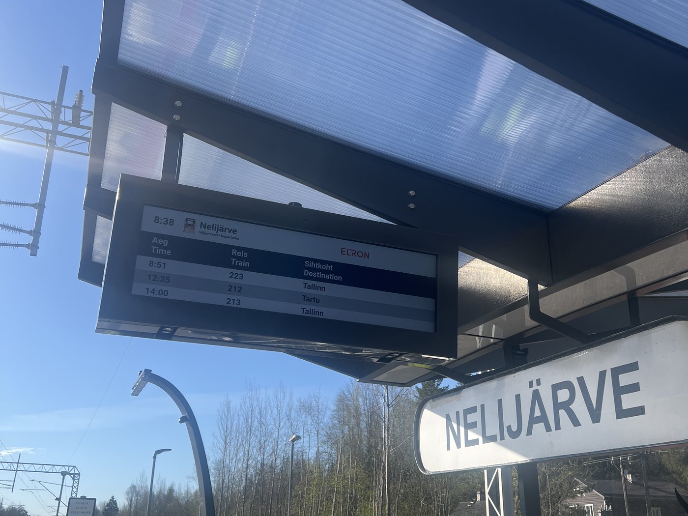 Ampron LCD passenger information display installed at Nelijärve railway stop, showing live Elron departure information