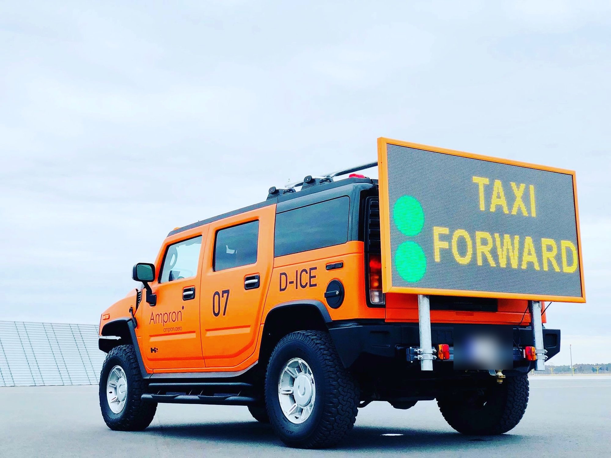 Vehicle-mounted Ampron LED sign on a de-icing support vehicle at Tallinn Airport, showing TAXI FORWARD with two green lights.