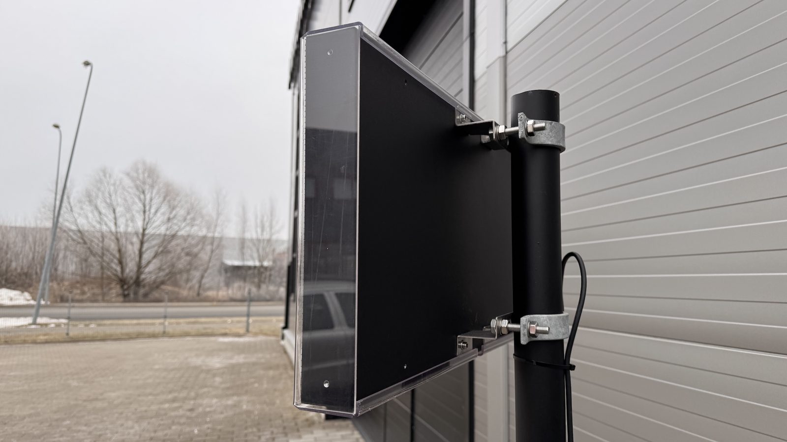 Ampron LED display mounted on a black pole with two galvanised pole clamps